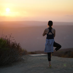 woman enjoying yoga a sunset - contact Yoga Oasis.